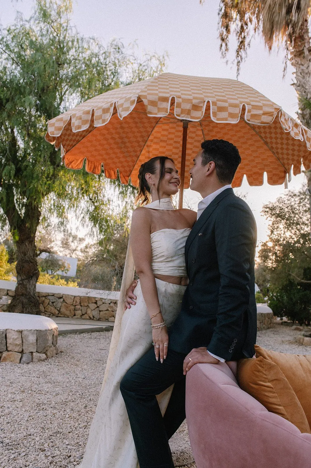 Bride and groom under a checkered umbrella at a destination wedding