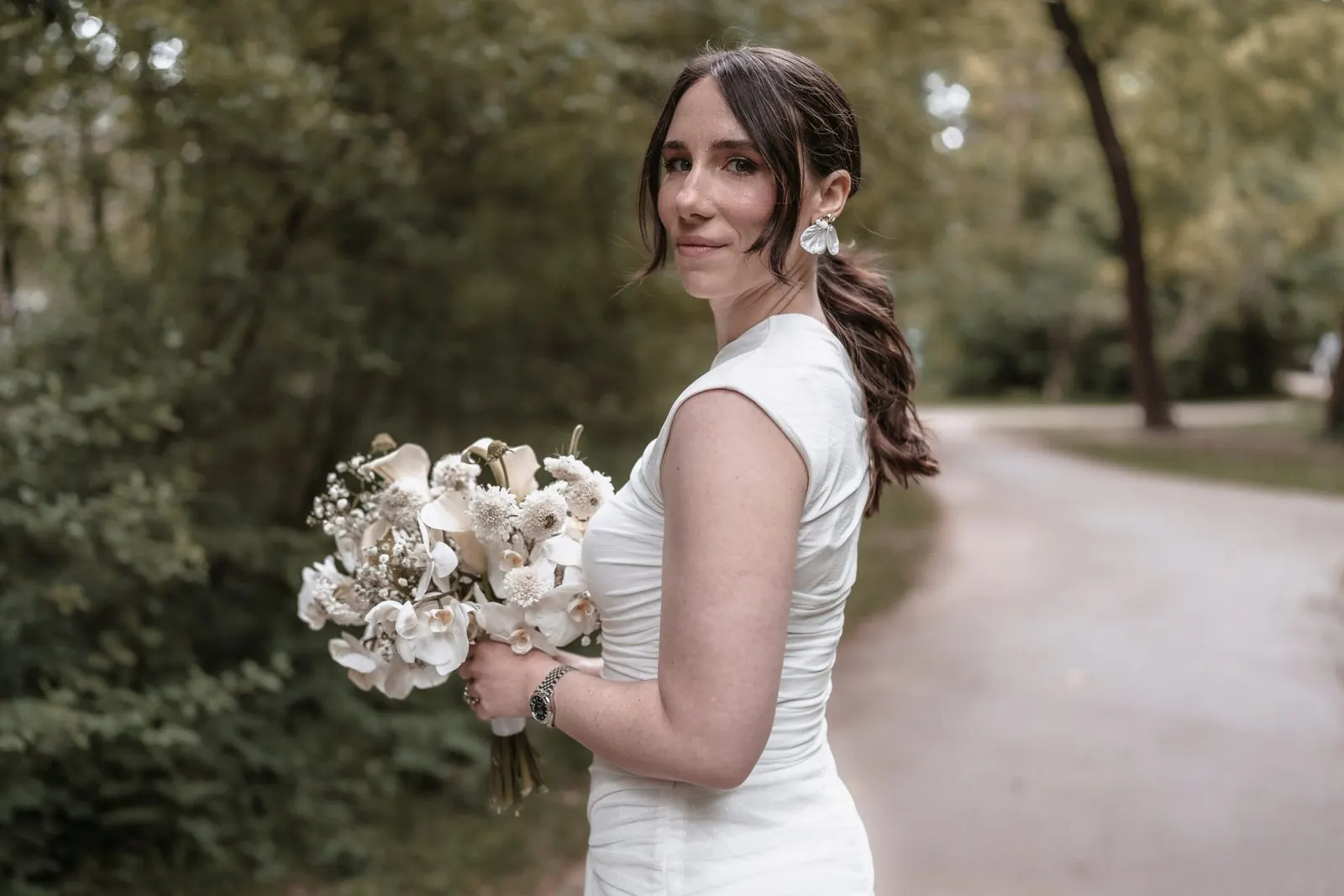 Bride in the park holding her bouquet